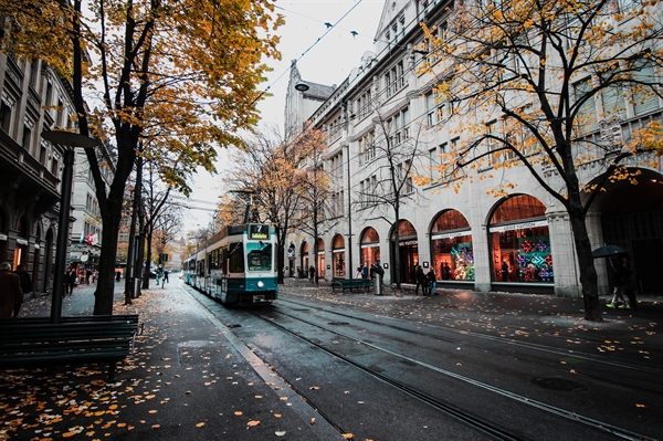 Tram riding down a high street in Europe